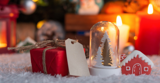 A Seasonal glowing delight. A blurred image of sparkling colorful lights. In the forefront is a tiny red package wrapped with white cord, promising a delight inside