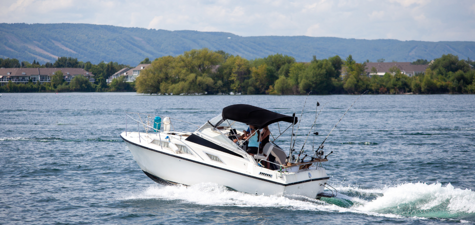 Motorboat cruising on a calm Canadian lake near forested shoreline.  