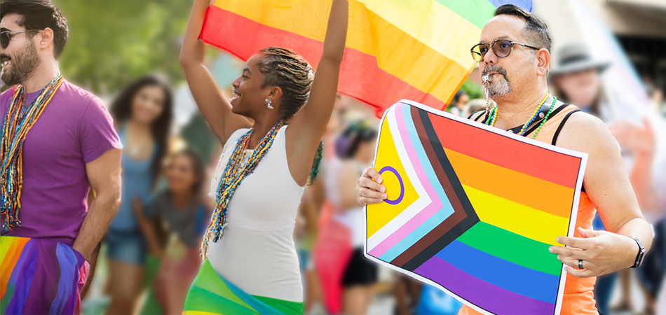 People walking with Pride Flags at a Pride parade.