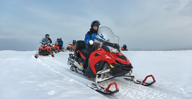 Riding on a snowmobile in Finland, female rider above the Arctic Circle
