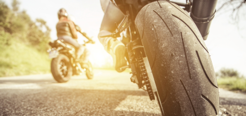 Motorcyclist wearing a helmet and protective gear for safer summer motorcycle riding.