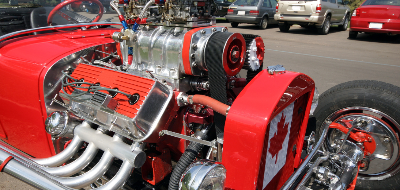 A high-performance red coloured street rod with aftermarket auto parts and a Canadian flag on the front.