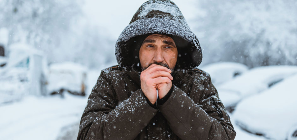 A man trying to warm his hands in winter.