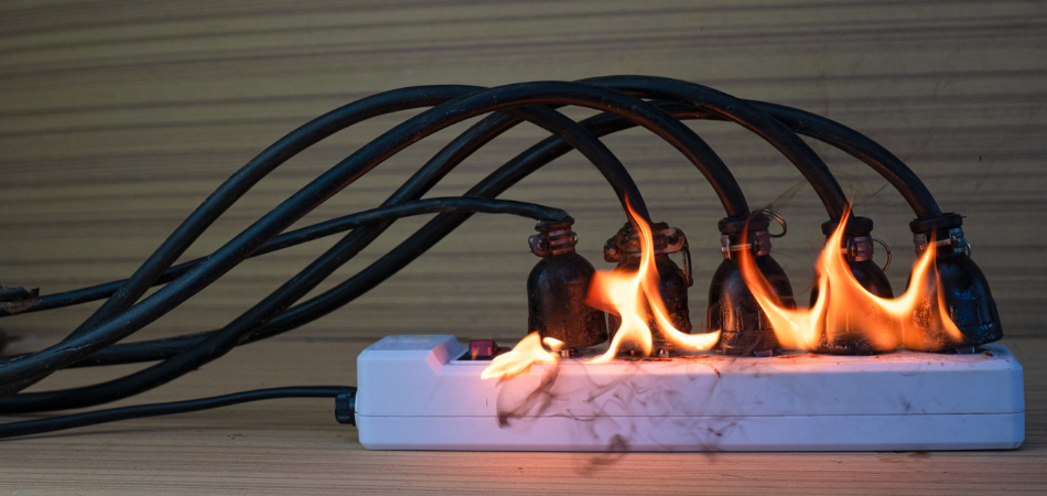Image shown of an overloaded power bar catching fire because of misuse and lack of electrical fire safety.