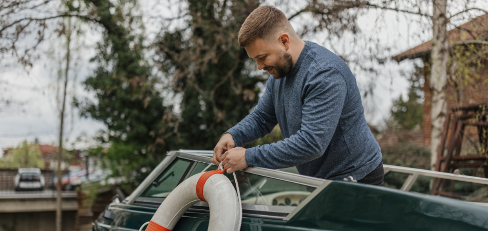 Man securing a lifebuoy on a boat, emphasizing safety and preparedness for boating insurance.  