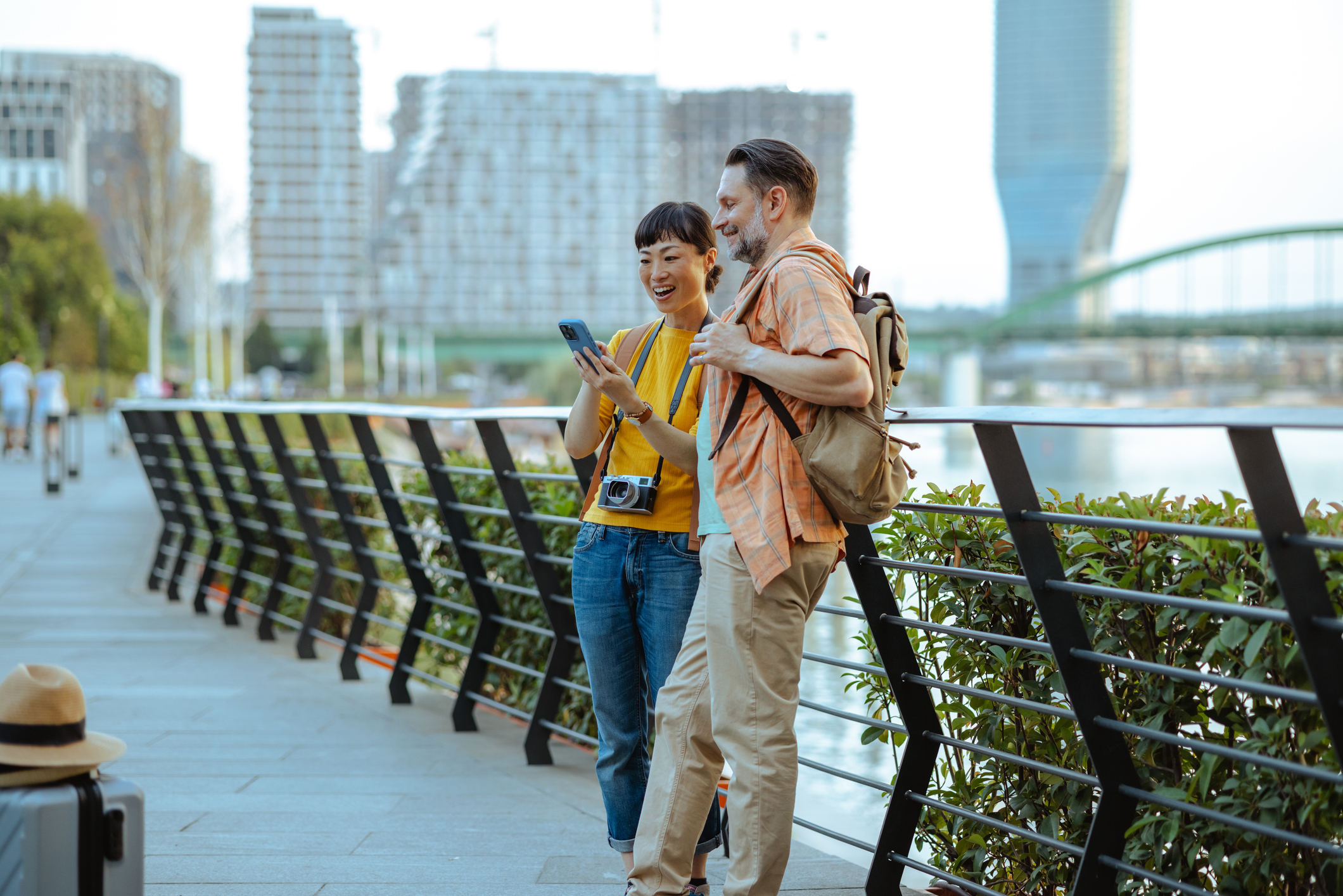 A couple smiling and looking at a phone on vacation