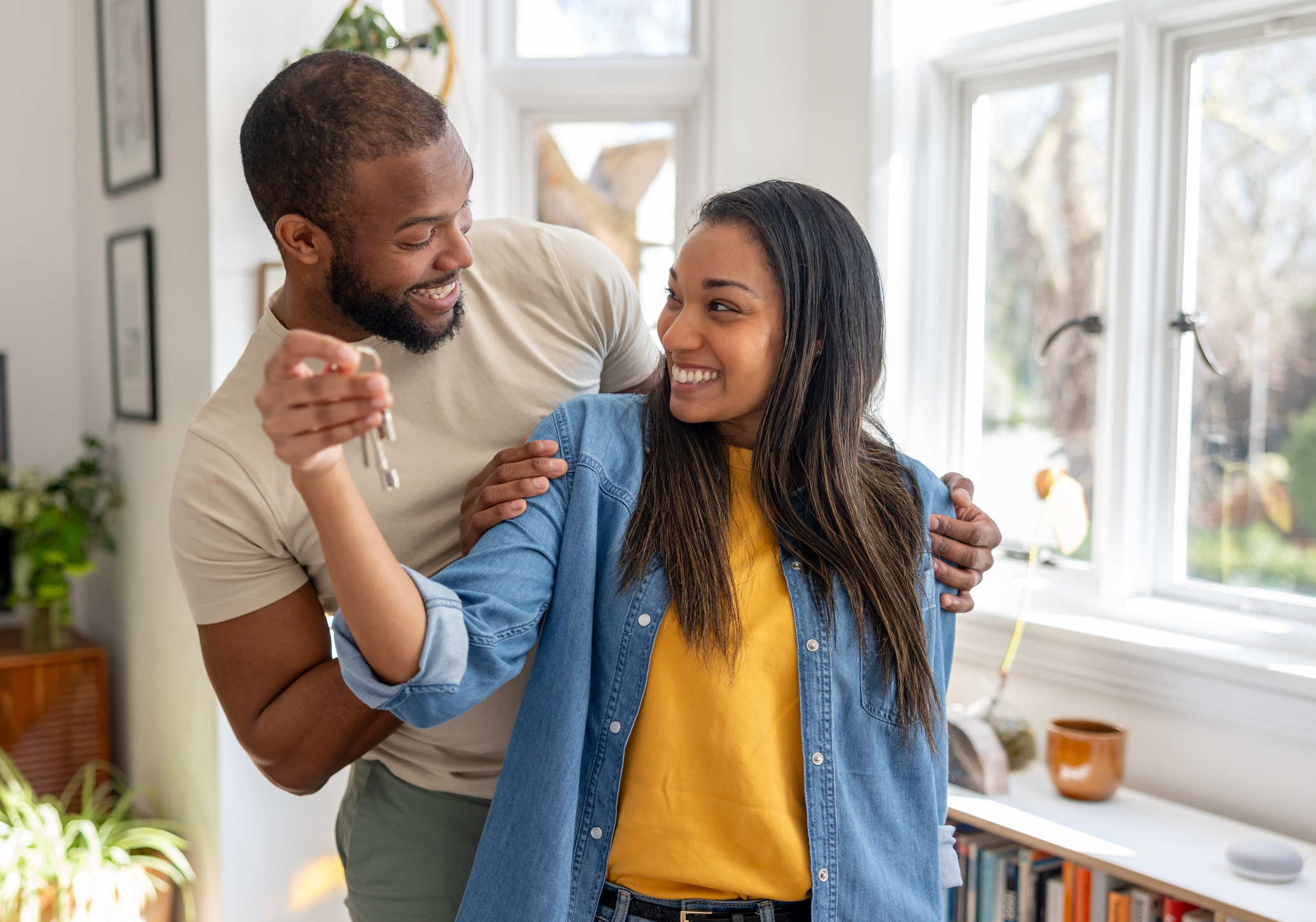 A smiling couple holding to keys to their new home