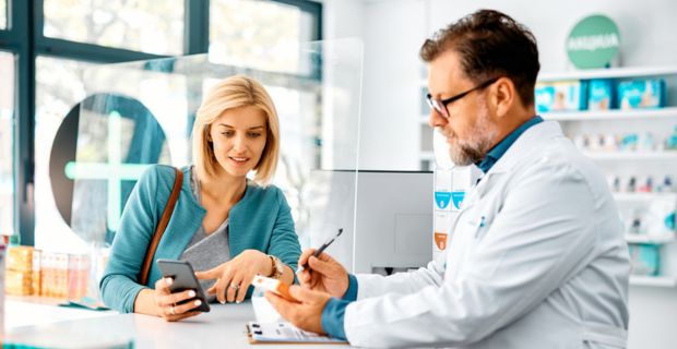 A woman getting a prescription filled at the pharmacy. 