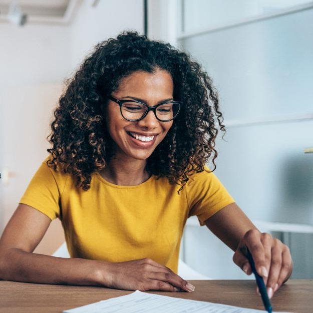 A woman sitting at her desk going-over paperwork. 