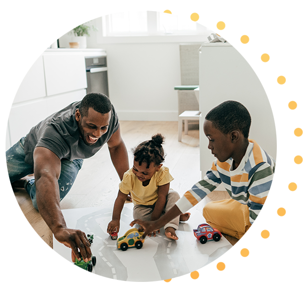 A man playing on the kitchen floor with his kids.