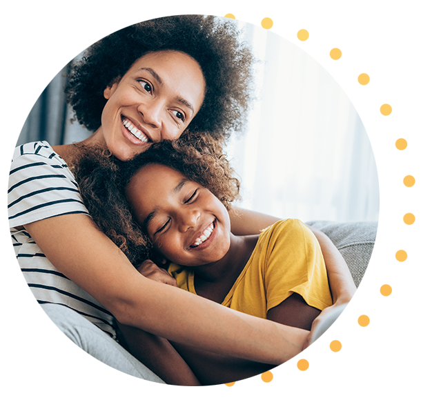 A woman and her child snuggling together on the couch.