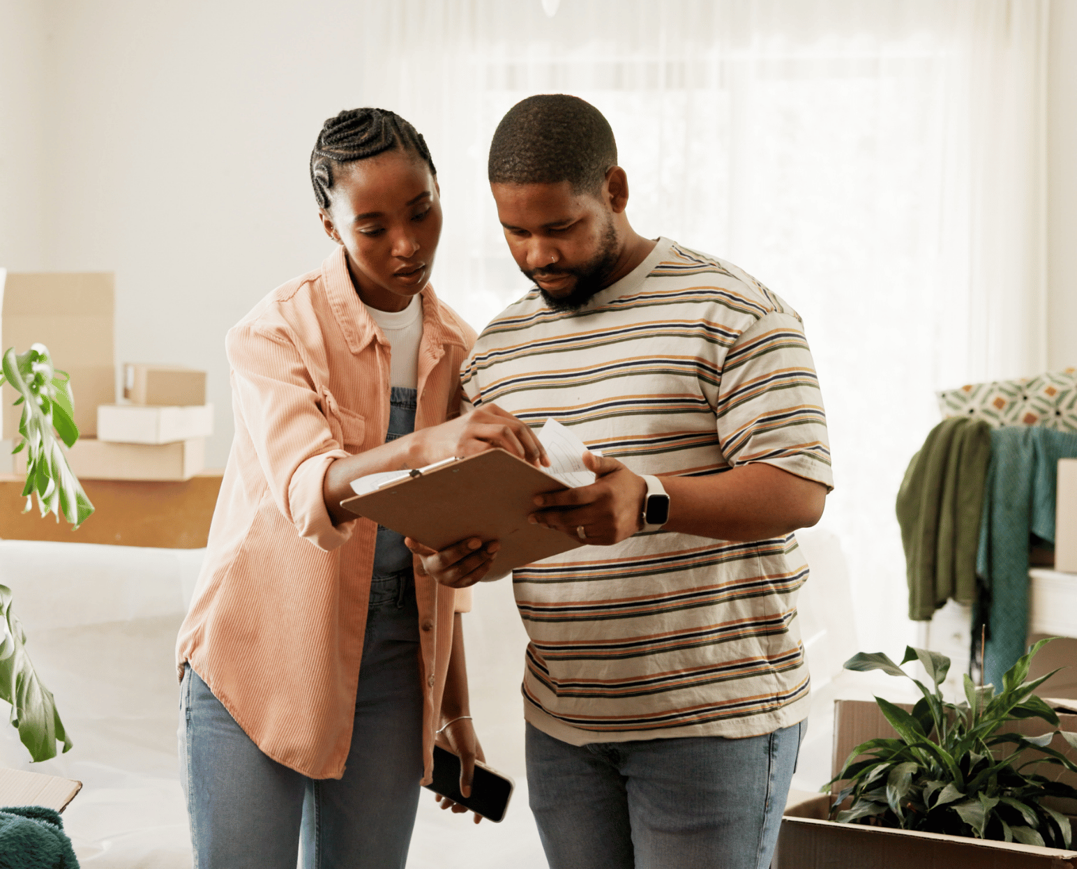 A couple in their home preparing a home inventory checklist of their belongings.