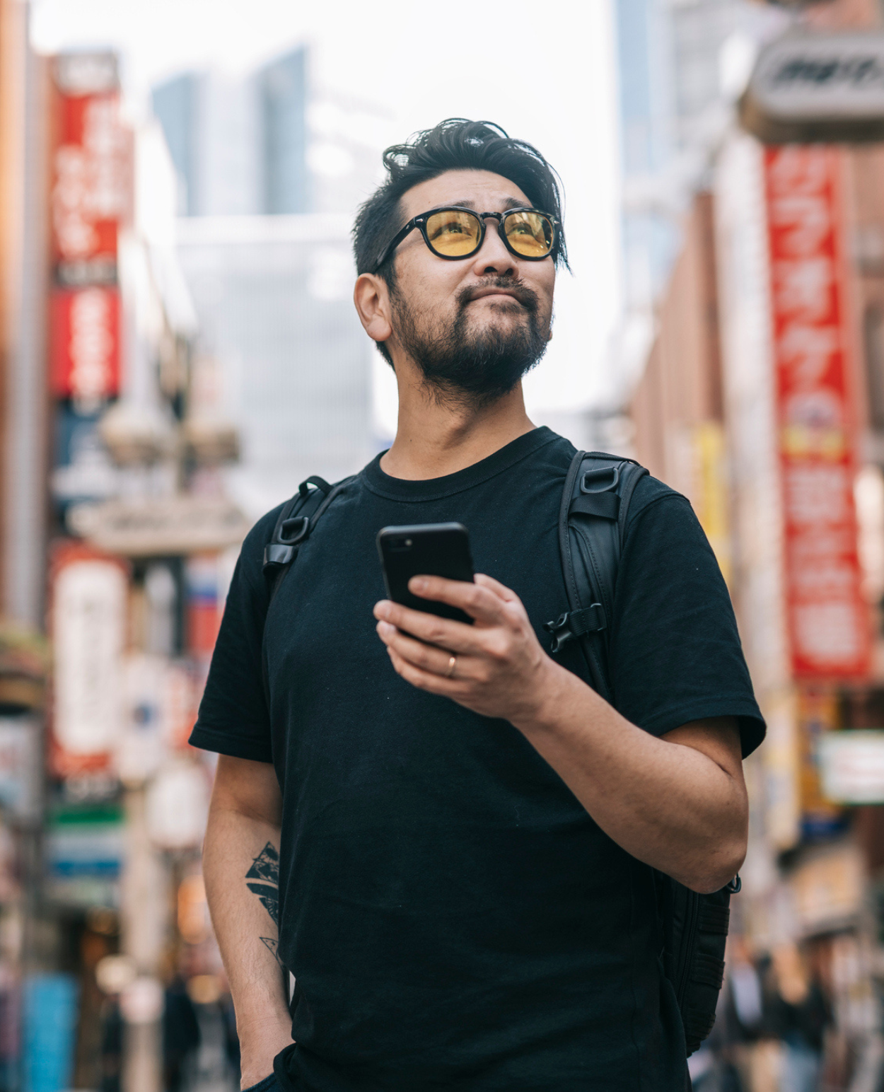 An Asian man in his mid-20's takes in the architecture on his vacation.