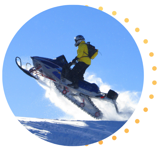 A snowmobiler catching air on their snowmobile.