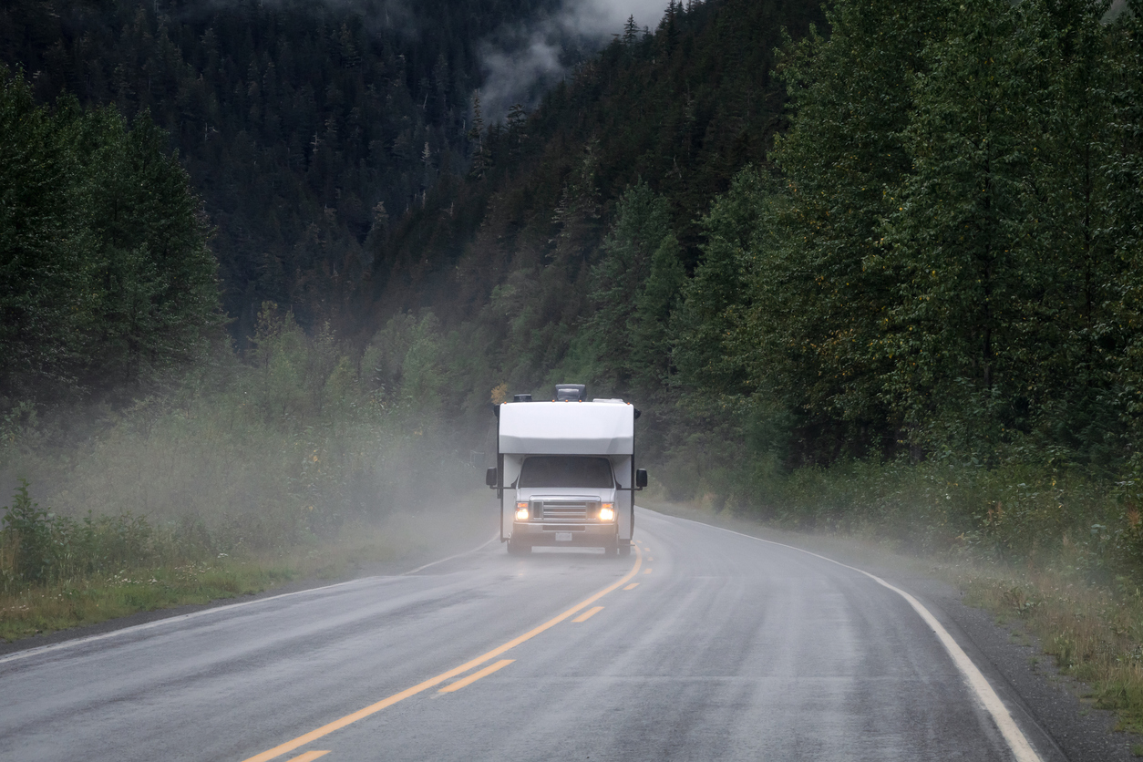 Motorhome travelling along a remote highway in northwestern British Columbia while it’s raining. 