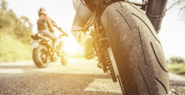 Motorcyclist wearing a helmet and protective gear for safer summer motorcycle riding. 