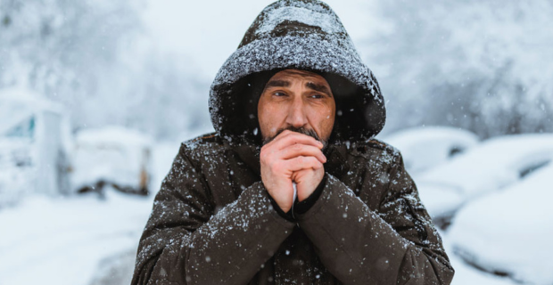 A man trying to warm his hands in winter.
